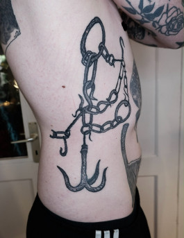 Roh gezeichnetes Blackwork-Tattoo von Jette mit Ketten, Ringen und Haken entlang der Körperseite. Die bewusst unregelmäßige Linienführung verbindet Dark-Medieval- und Prison-Style-Einflüsse.