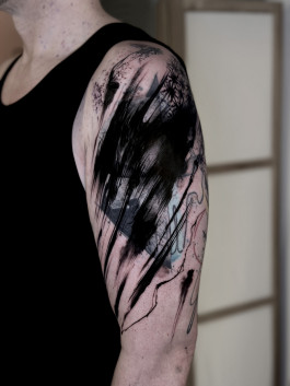Abstraktes Blastover Tattoo am Oberarm von Dennis Awe