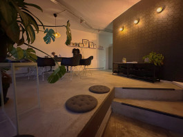 Eingangsbereich des Beechhouse Tattoo Studios in Bochum mit Sitzbank, Pflanzen und dunkler Wand.